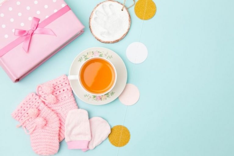 Tasse Tee und Babyzeug auf dem Tisch