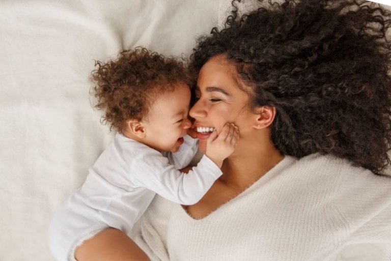 Mutter und Baby liegen auf dem Bett