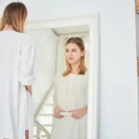 besorgte Frau, die Spiegel betrachtet