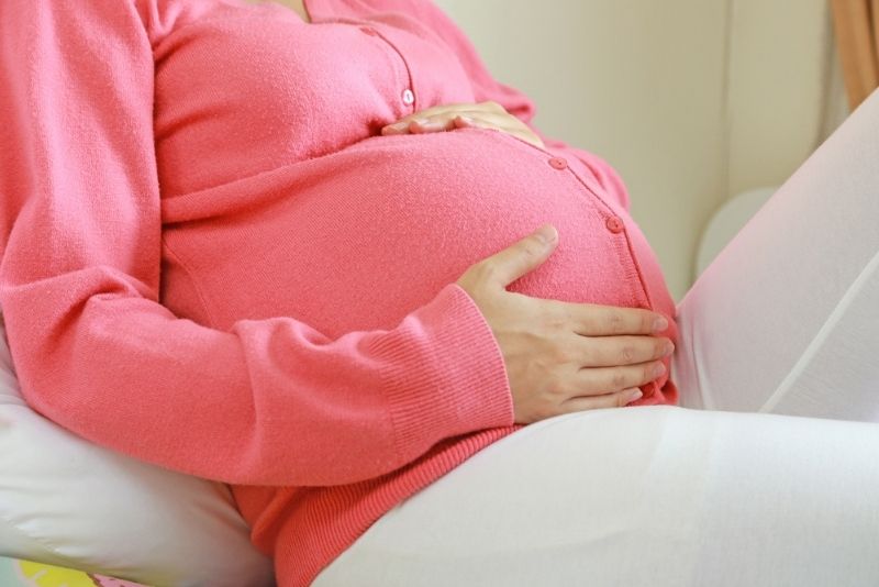 schwangere Frau hält ihren Bauch
