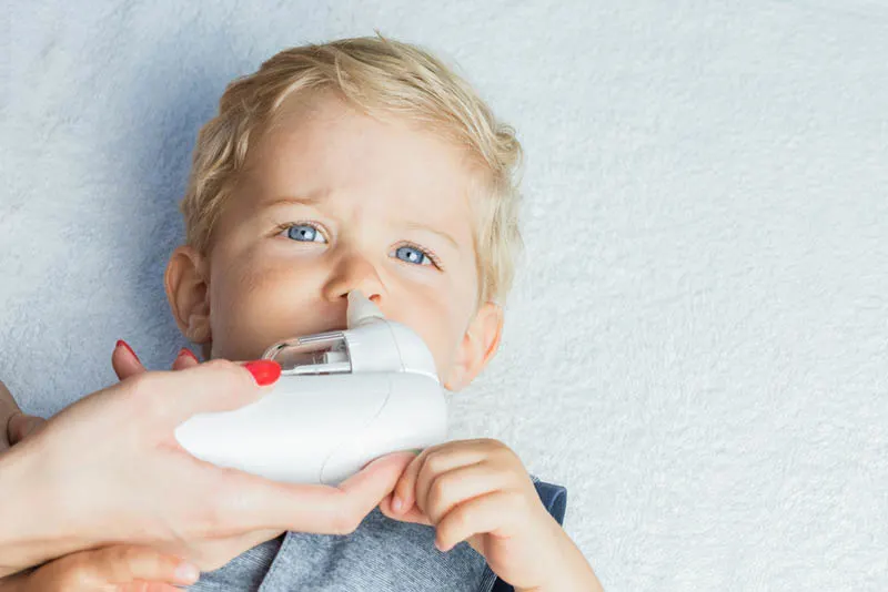 Mutter mit elektrischem Baby-Nasensauger zur Reinigung der Nase