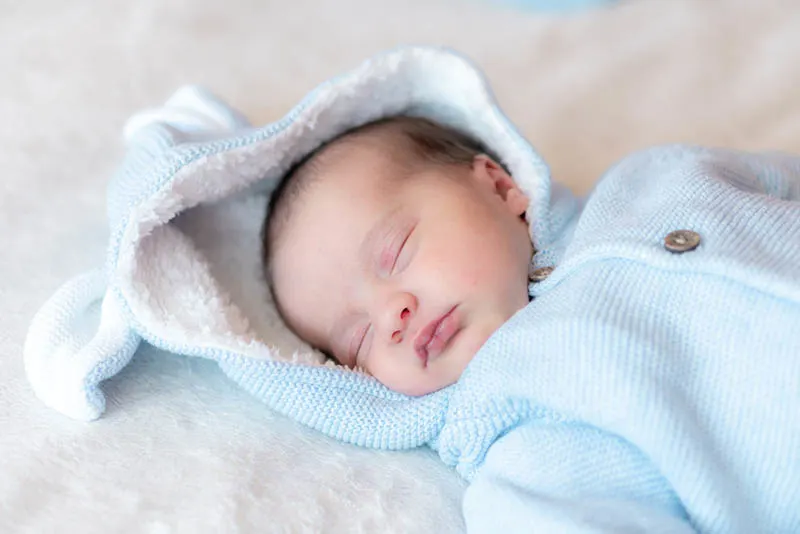 Neugeborenes Baby in süßen Kleidern schlafend