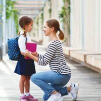 Mutter spricht vor der Schule mit Tochter