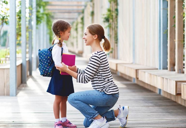 Mutter spricht vor der Schule mit Tochter