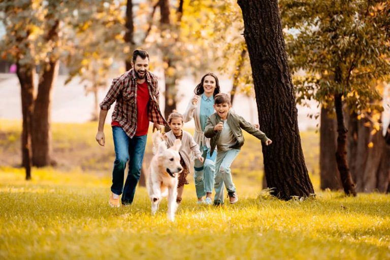 glückliche Familie, die mit Hund läuft