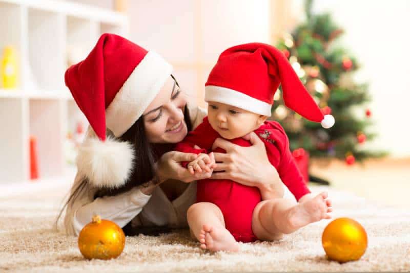 junge Mutter spielt mit ihrem Baby für Weihnachten