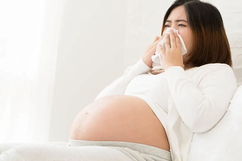 junge schwangere Frau mit verstopfter Nase