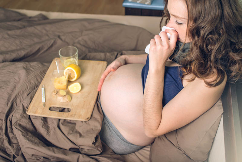 kranke schwangere Frau, die kleinen Tisch mit Zitrone hält