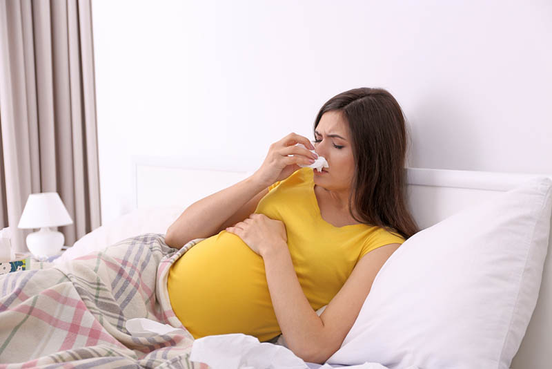kranke schwangere Frau im Bett liegend