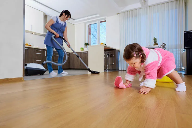lustiges kleines Mädchen, das ihrer Mutter hilft, das Haus zu säubern
