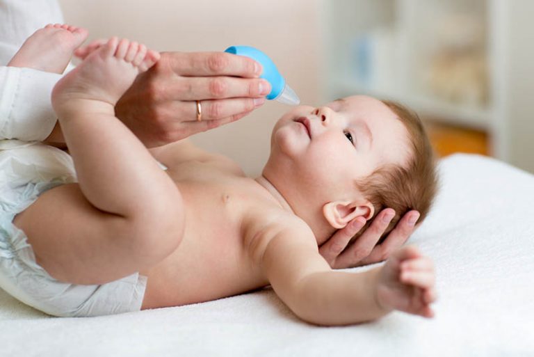 Frau mit Nasensauger für Baby laufende Nase