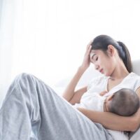 besorgte Frau, die Baby stillt