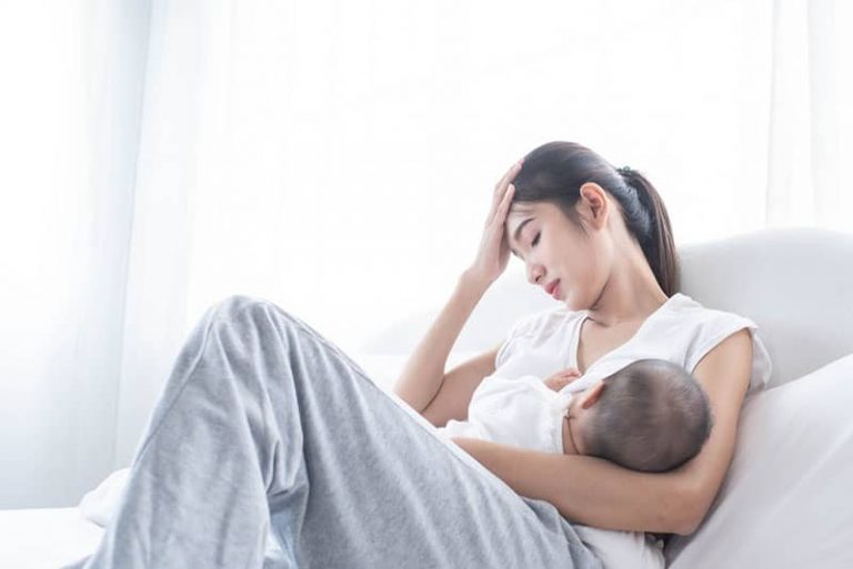 besorgte Frau, die Baby stillt