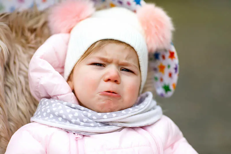 süßes Baby in Winterkleidung weinen