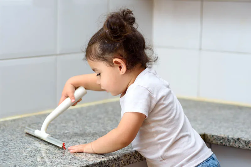 süßes kleines Mädchen Reinigung Küche Marmor Bar