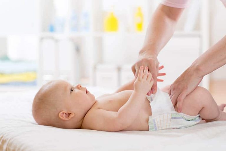 Mutter, die Babywindel wechselt