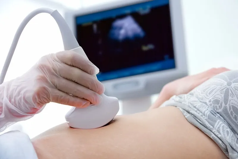 Arzt macht eine Ultraschalluntersuchung des Bauches einer schwangeren Frau in der Klinik