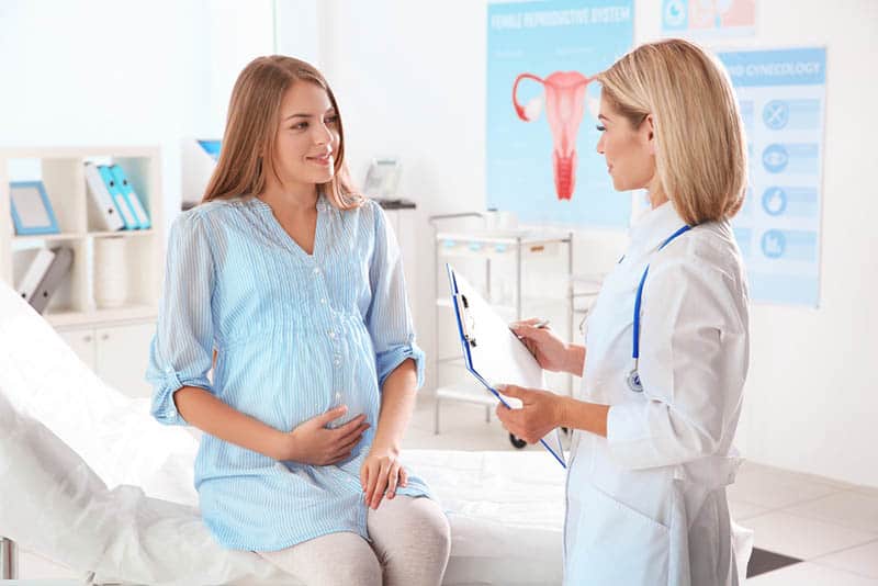 Arzt untersucht schwangere Frau