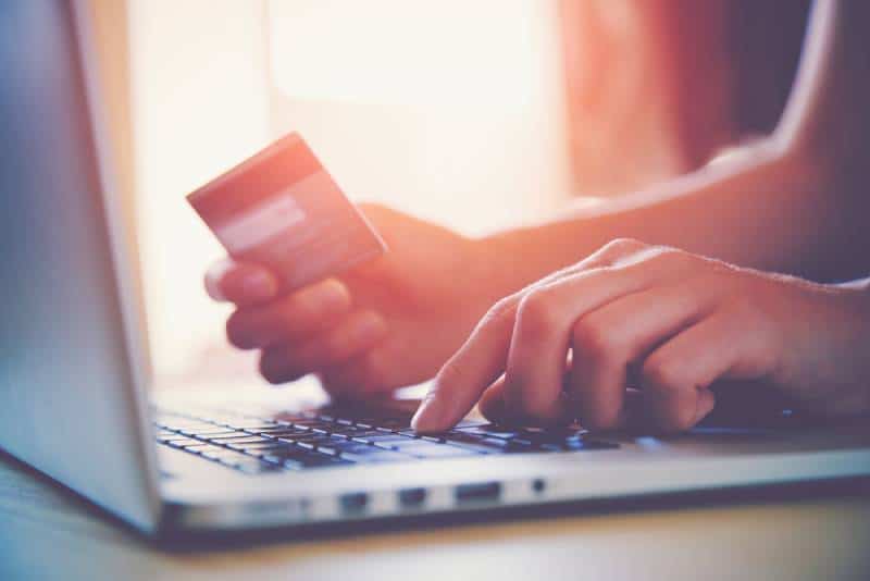 Frau hält Kreditkarte für Online-Shopping