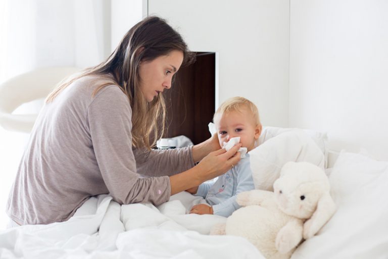 Mutter putzt Baby laufende Nase zu hause