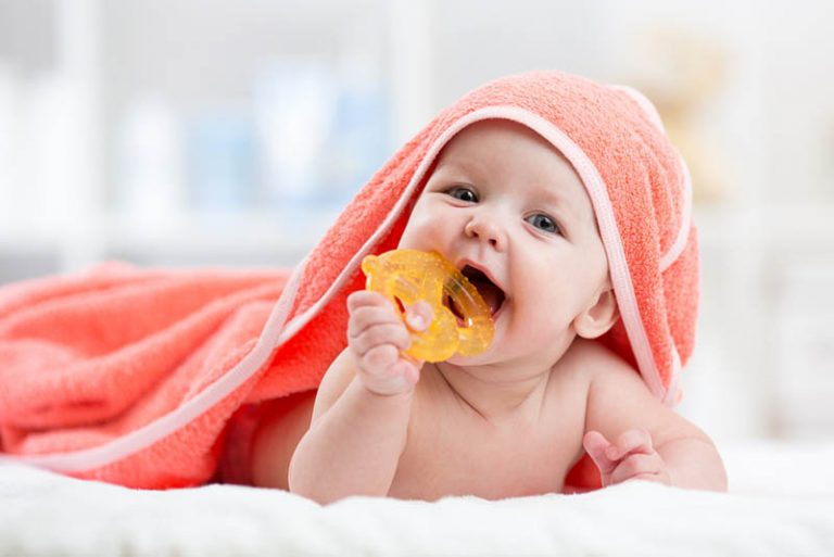 süßes Baby mit Handtuch beißendem Beißring