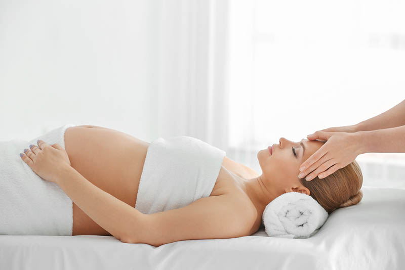entspannte schwangere Frau mit Massage im Spa-Center