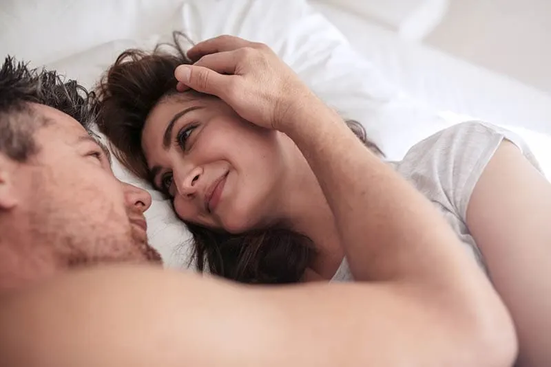 romantisches junges Paar, das im Bett kuschelt