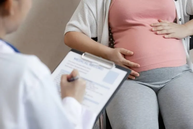 schwangere Frau bei Ärzten, die den Geburtsplan überprüfen