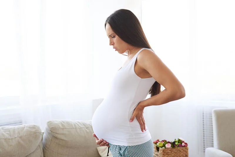 schwangere Frau, die Rückenschmerzen fühlt