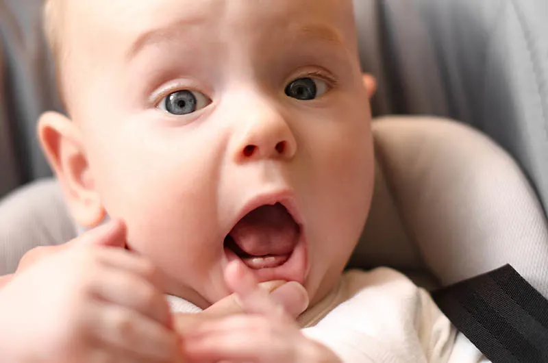 süßes kleines Baby zeigt seine ersten Zähne