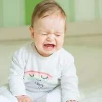 Baby schreit und weint auf dem Bett