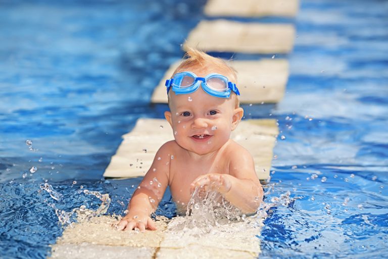 süßes Baby mit Schwimmbrille im Pool