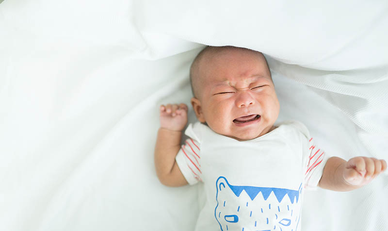 kleines Baby, das hysterisch weint, während es im Bett liegt