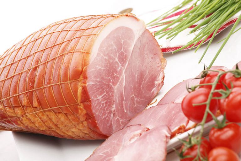 gekochter Schinken in Scheiben geschnitten mit Tomate und Zwiebel auf dem Tisch