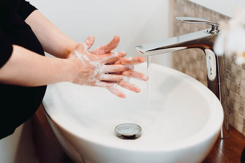 schwangere Frau Hände waschen und Finger mit Wasser und Seife reinigen