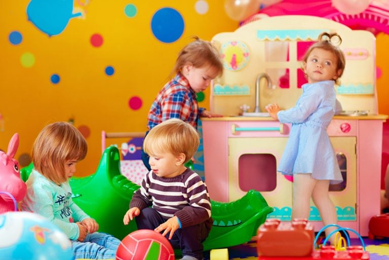 süße Kinder spielen im bunten Kindergarten