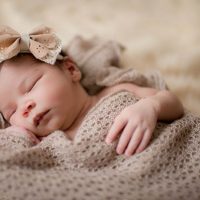 Süßes neugeborenes Baby Mädchen schlafend auf Bett