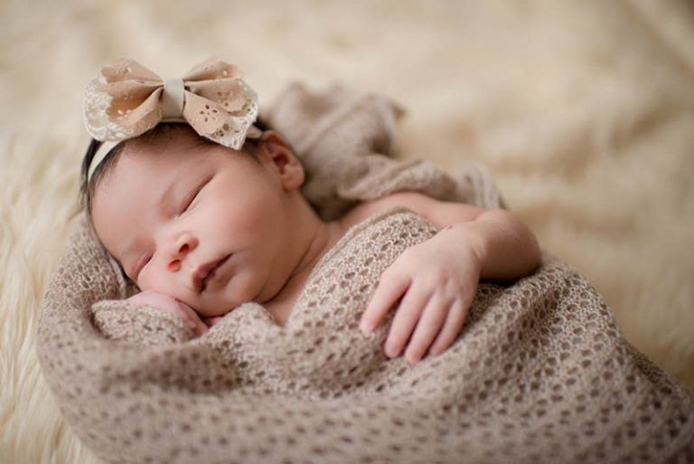 Süßes neugeborenes Baby Mädchen schlafend auf Bett