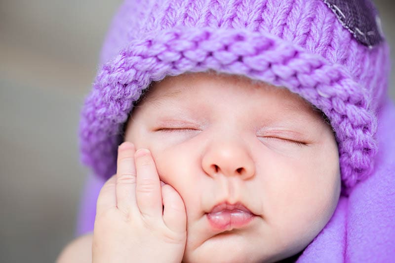 süßes Baby trägt einen lila Hut schlafen und träumen