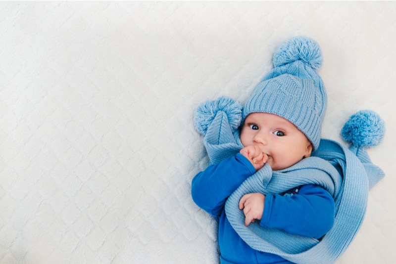 Baby gekleidet in Winterschal und Mütze