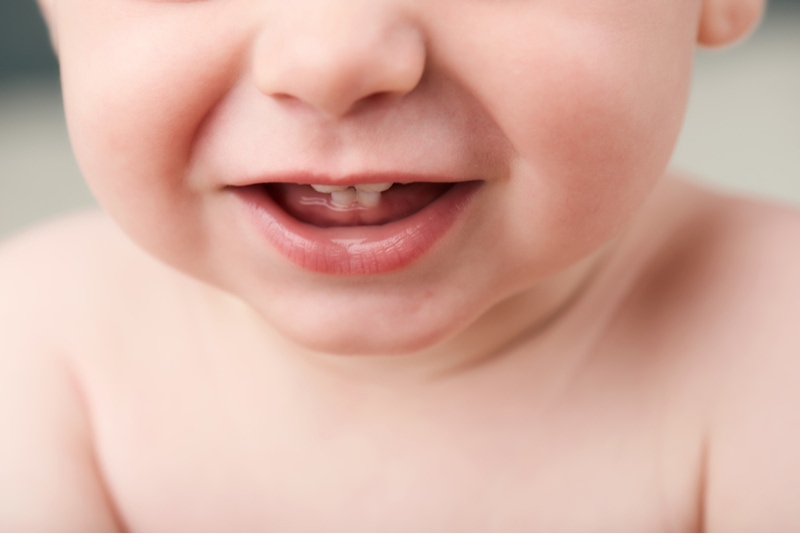 Babys offener Mund zeigt seine ersten Zähne