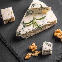 köstlicher Gorgonzola-Käse mit Walnüssen auf dem schwarzen Brett