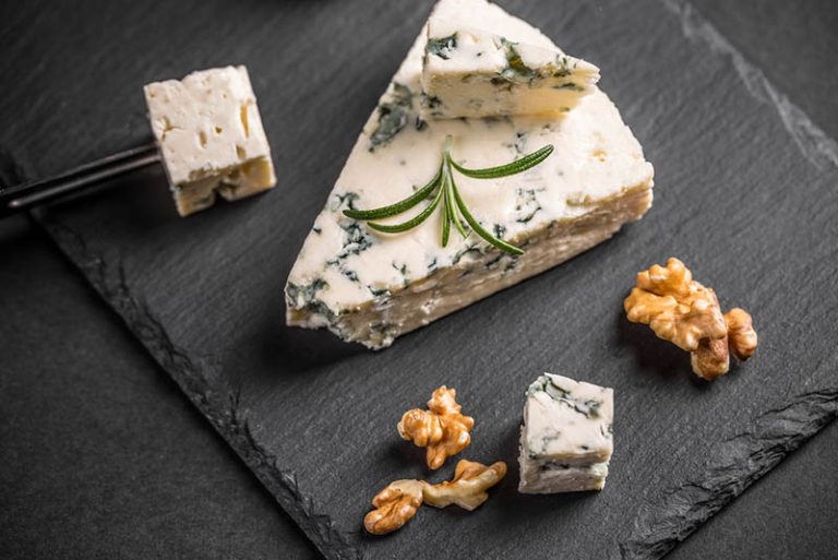 köstlicher Gorgonzola-Käse mit Walnüssen auf dem schwarzen Brett