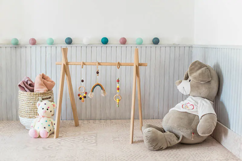 Holz-Babygymnastik mit Spielzeug im Schlafzimmer