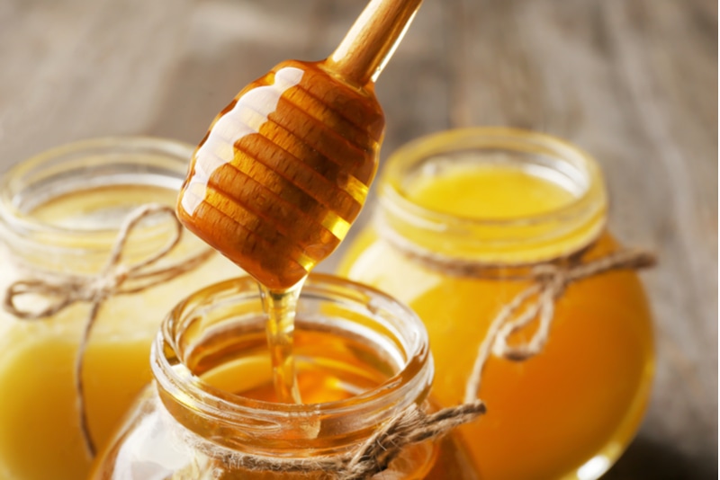 Aromatischen Honig in ein Glas gießen