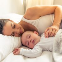 junge Mutter und ihr süßes kleines Baby schlafen