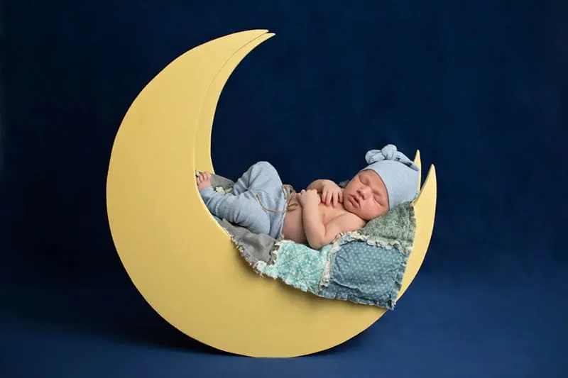 Neugeborenes Baby Junge trägt Pyjamahose und eine Schlafmütze auf Fotoshooting