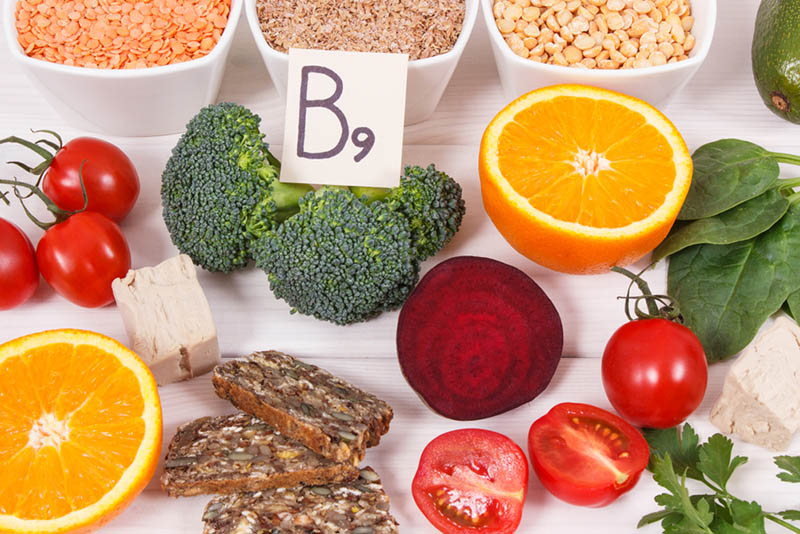 Nützliche Zutaten mit Vitamin B9 auf weißem Holztisch