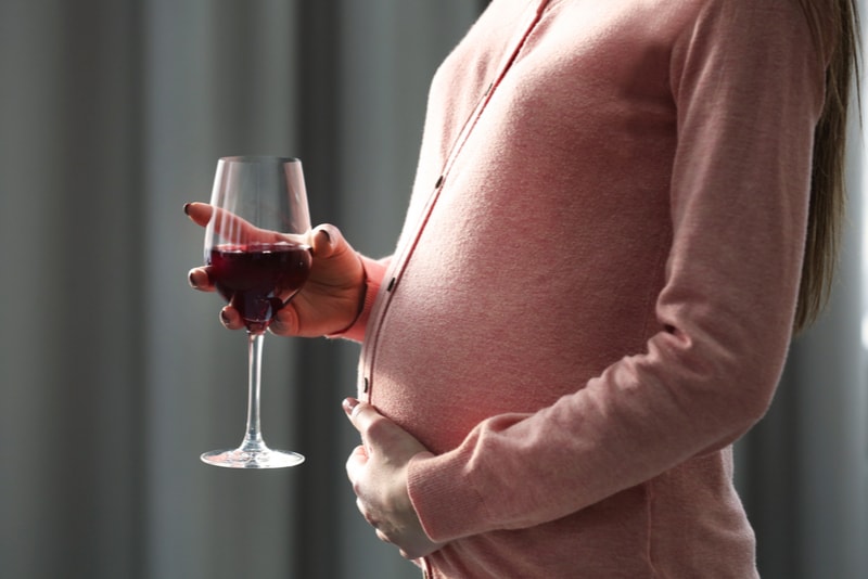 Schwangere Frau mit Glas Rotwein