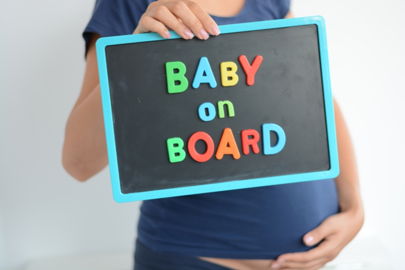 Schwangere hält ein Baby an Bord